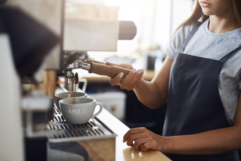 Close up of espresso shots pouring into cups. Delicious coffee to start your day.
